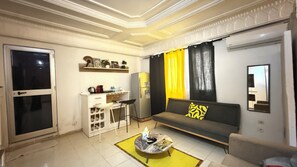 Comfort Studio | Living area | 32-inch flat-screen TV with cable channels, TV, books - Villa Jade (Dakar)