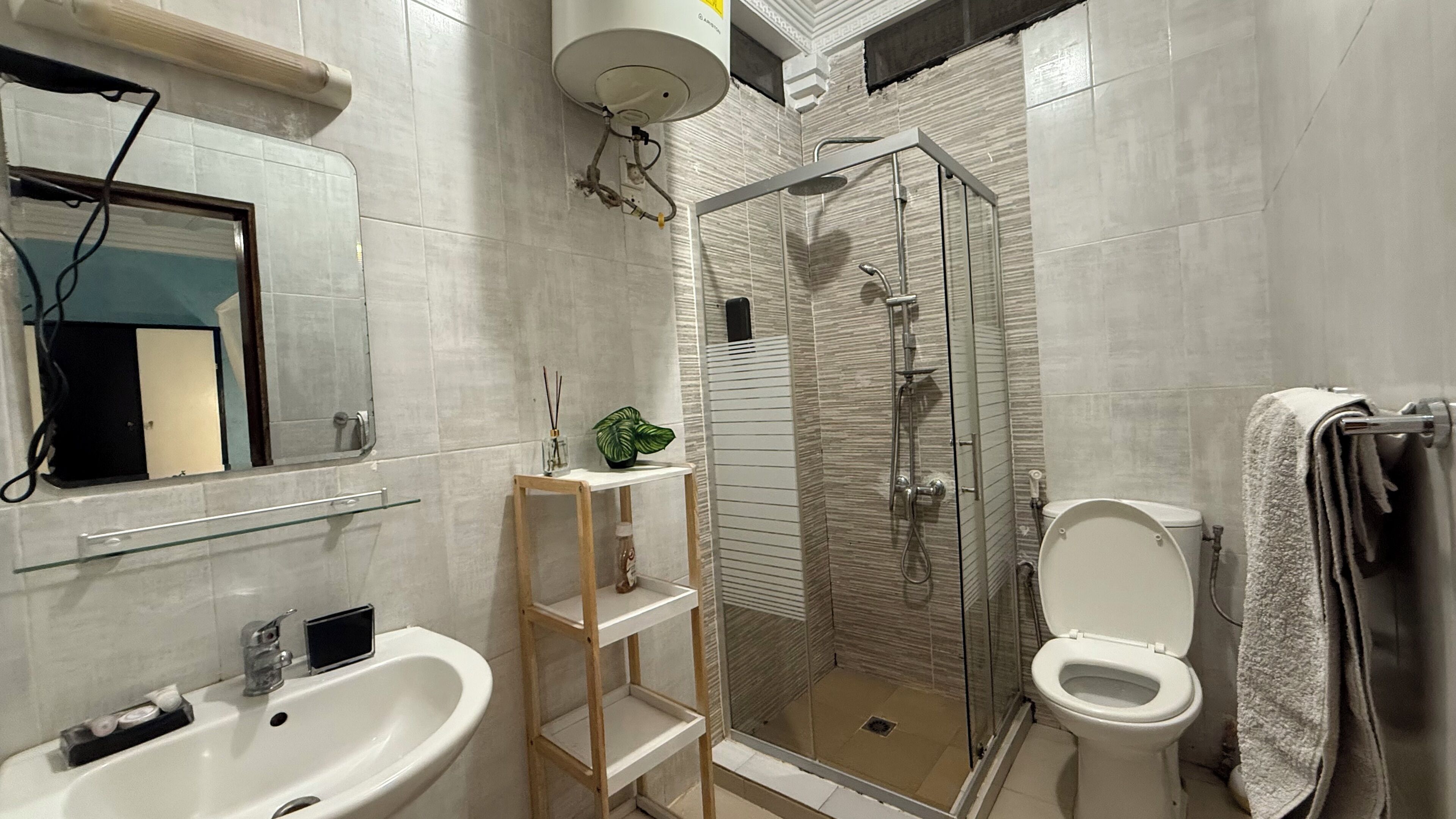 Une salle de bain moderne avec une douche à parois de verre, des toilettes, un lavabo et un miroir.