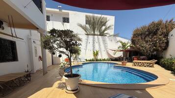 Een buitenzwembad en ligstoelen