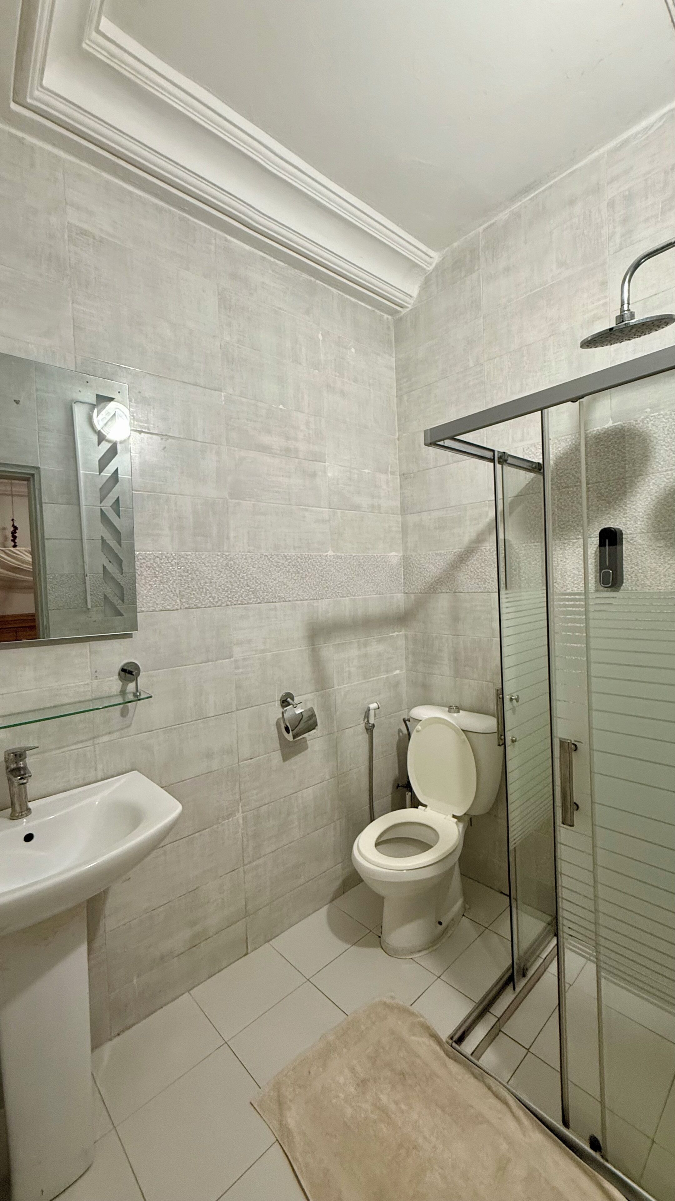 A bathroom with a sink, toilet, and glass-enclosed shower.