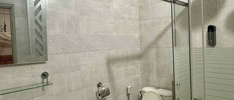A bathroom with a sink, toilet, and glass-enclosed shower.