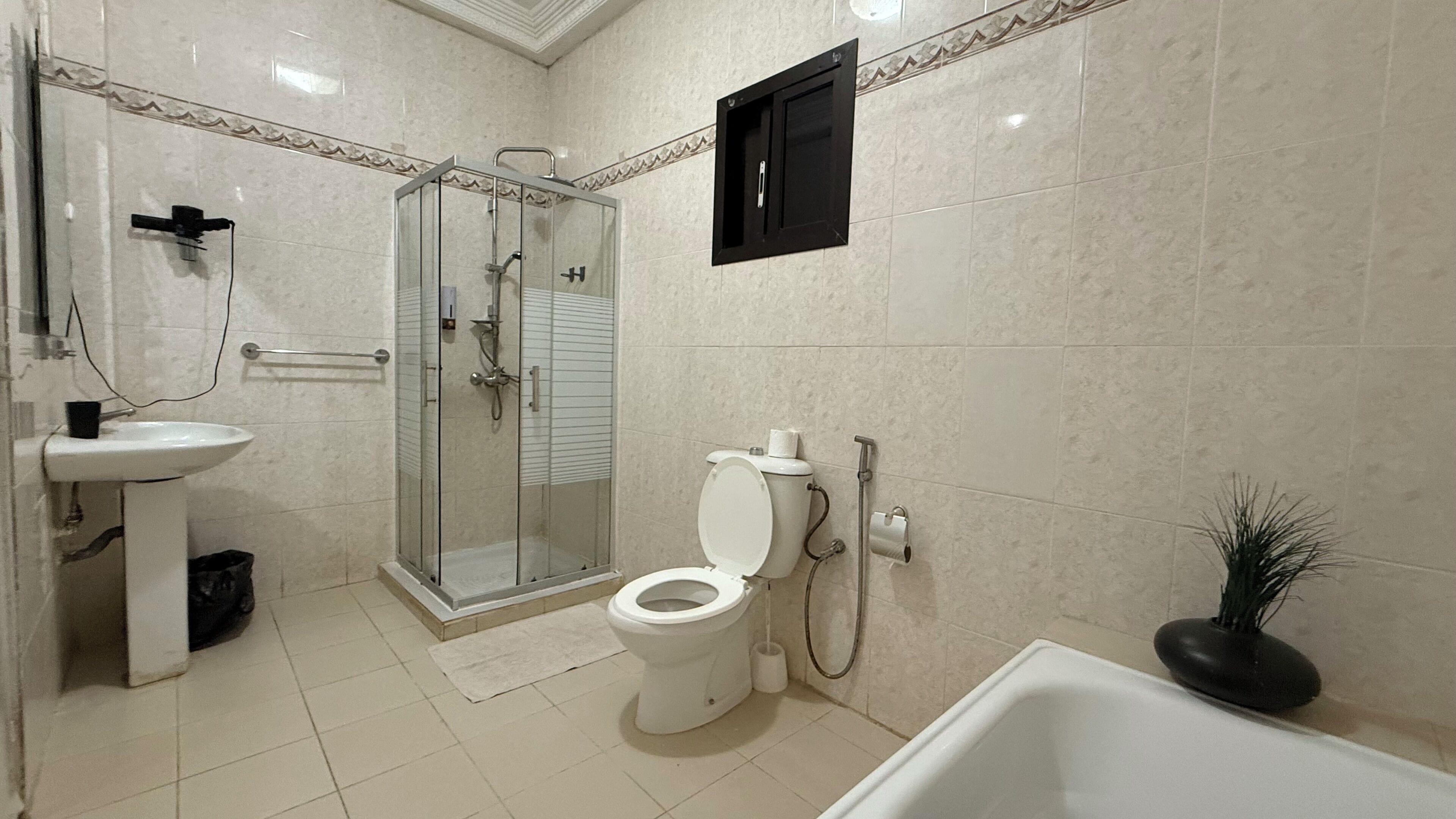 A bathroom with a toilet, sink, shower, and bathtub.