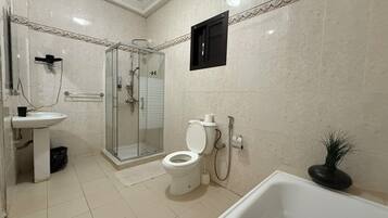 A bathroom with a toilet, sink, shower, and bathtub.