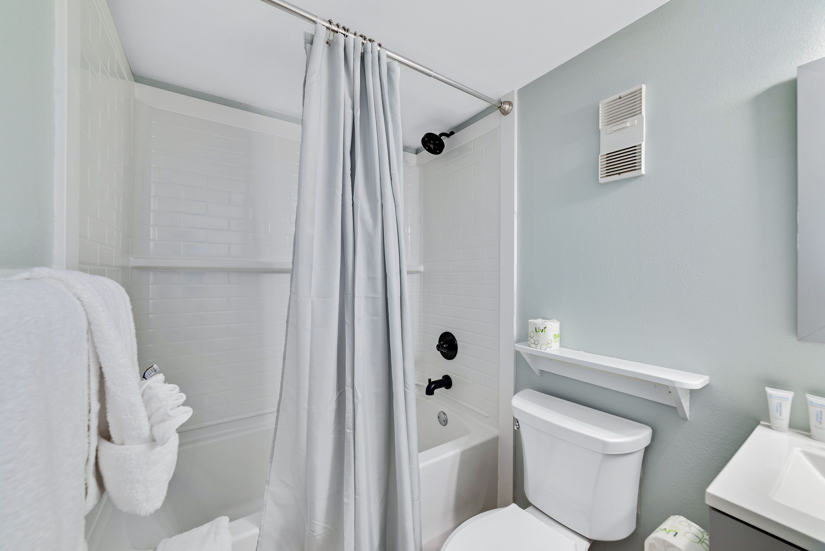 Ein modernes Badezimmer mit Badewanne, Toilette und Duschvorhang.