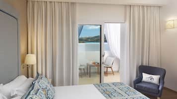 Une chambre d’hôtel avec un lit, une chaise, une table et une vue sur un balcon équipé d’une table et de chaises.