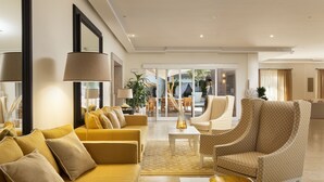 Ein modernes Wohnzimmer mit einer Couch, Sesseln und einem Couchtisch.