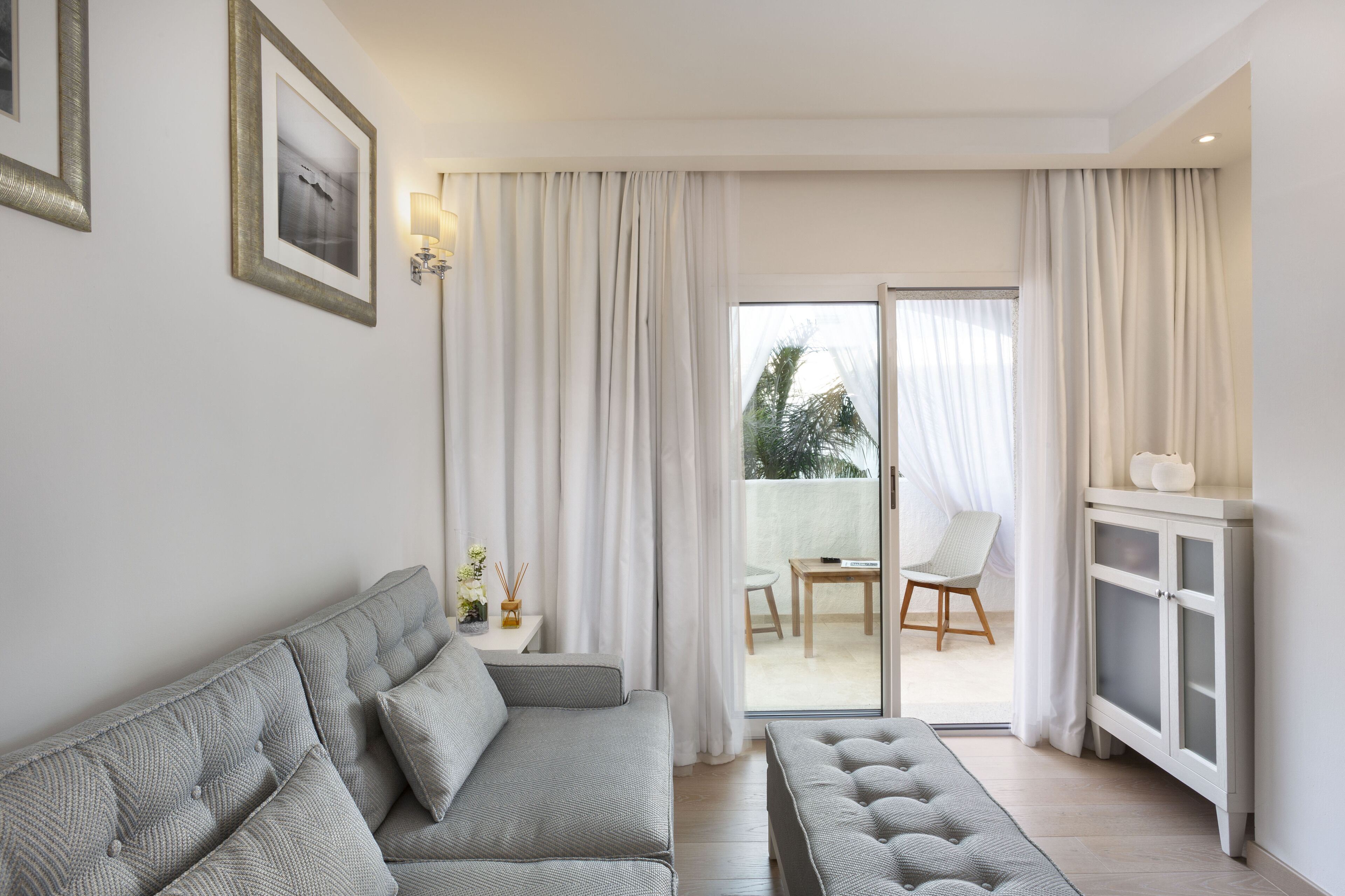 Un salon moderne avec un canapé, un meuble et une vue sur l’extérieur.