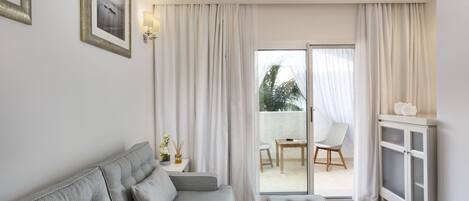 A modern living room with a sofa, a cabinet, and a view to the outside.