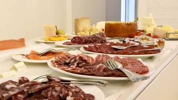 A buffet with various meats, cheeses, and fruits.