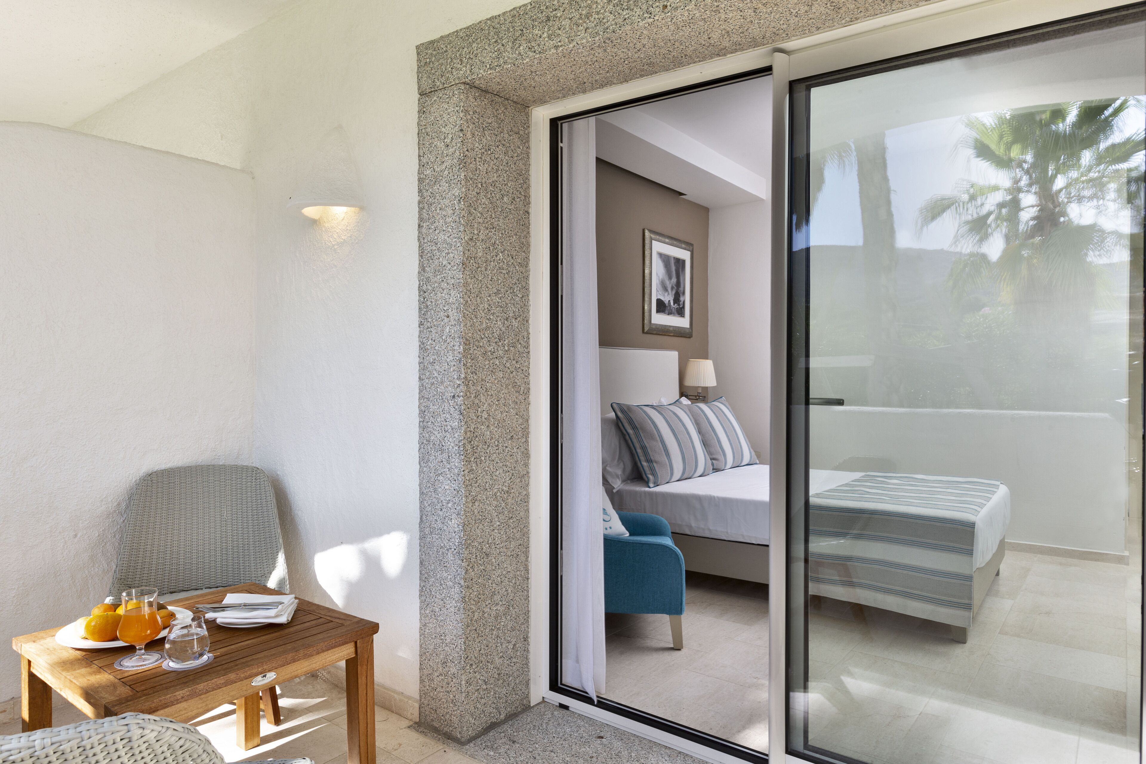 A room with a bed, a table with drinks, and a chair.