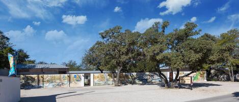 A building with a mural on the side, a parking lot, and a clear blue sky.