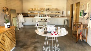 A modern interior with a central round table displaying various products, wooden furniture, and a clean, organized layout. - Hotel Flora & Fauna (Wimberley)