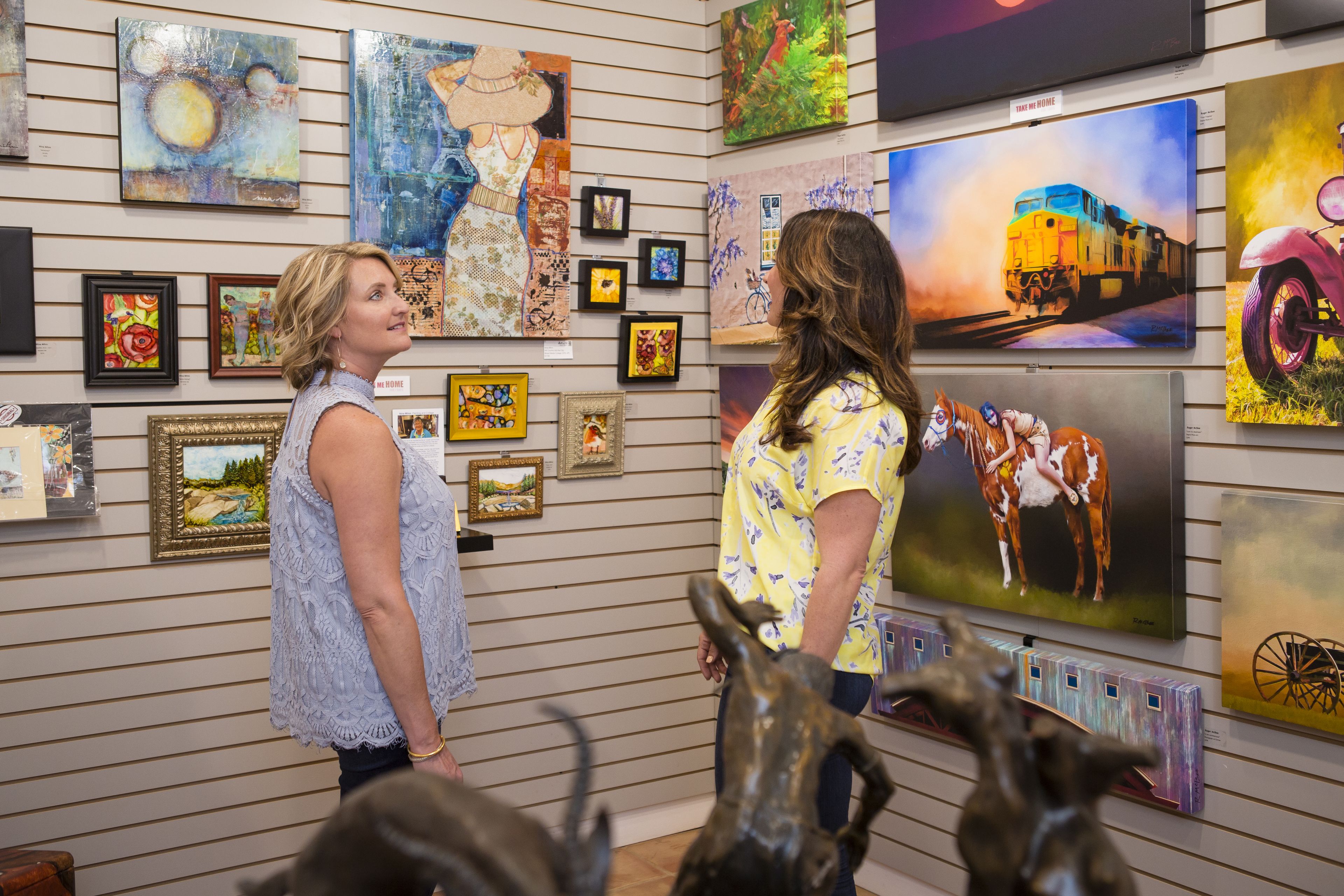 Two people examining artwork in an art gallery.