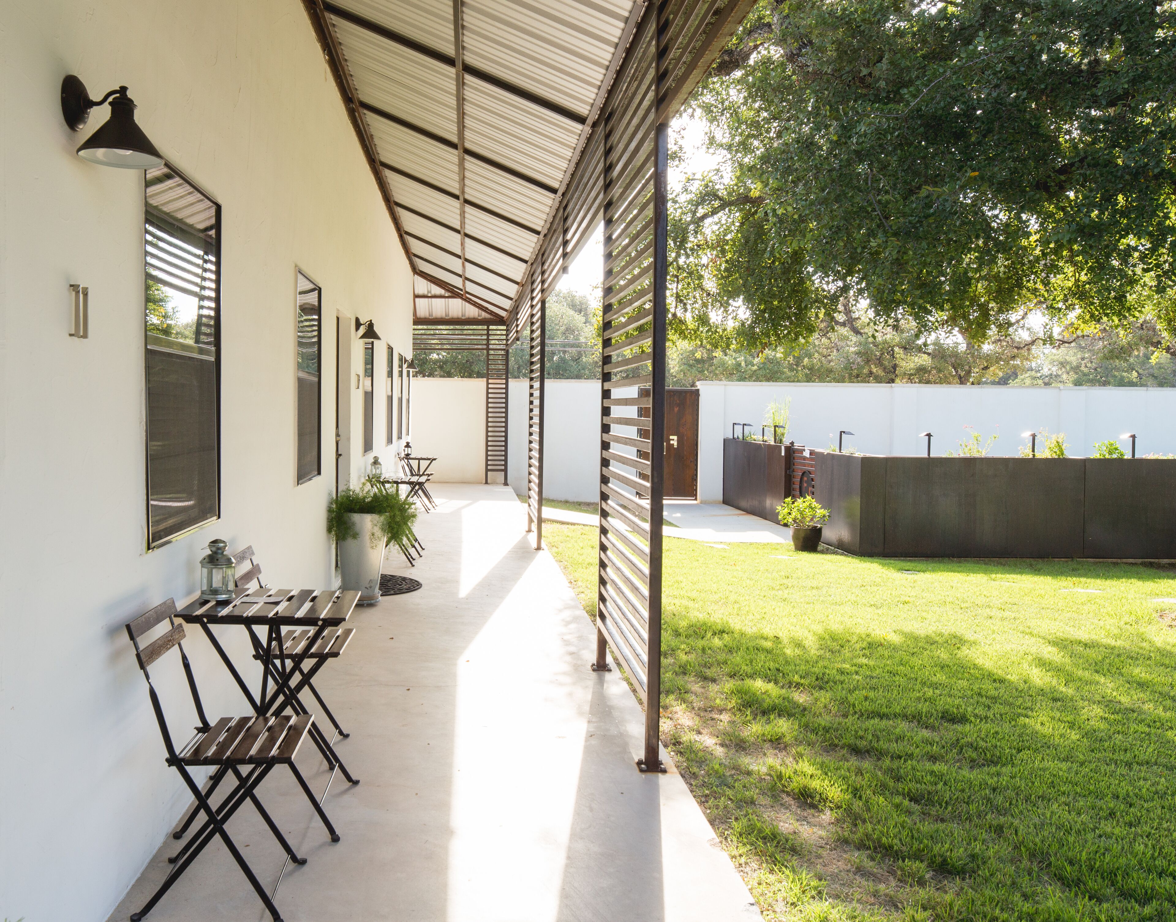 Un patio techado con mobiliario exterior, un jardín y vistas del entorno.