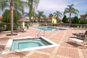 Un área de piscina con sillas de descanso y un jacuzzi.