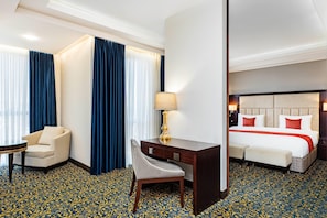 A hotel room with a bed, a desk, a chair, and a small table.