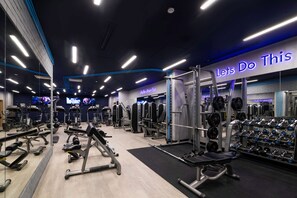 Ett modernt gym med olika typer av träningsutrustning, en motiverande skylt och ett område för styrketräning.