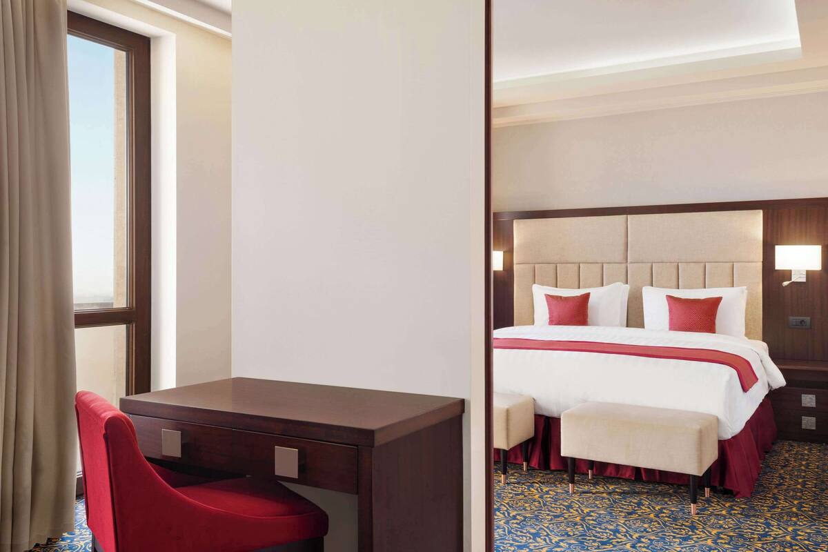Une chambre d’hôtel avec un lit, un bureau et une chaise.