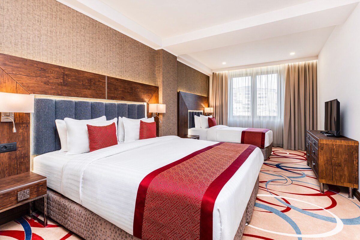 Familie suite (1 King Bed, 1 Single Bed) | Een minibar, een kluis op de kamer, een bureau, een laptopwerkplek