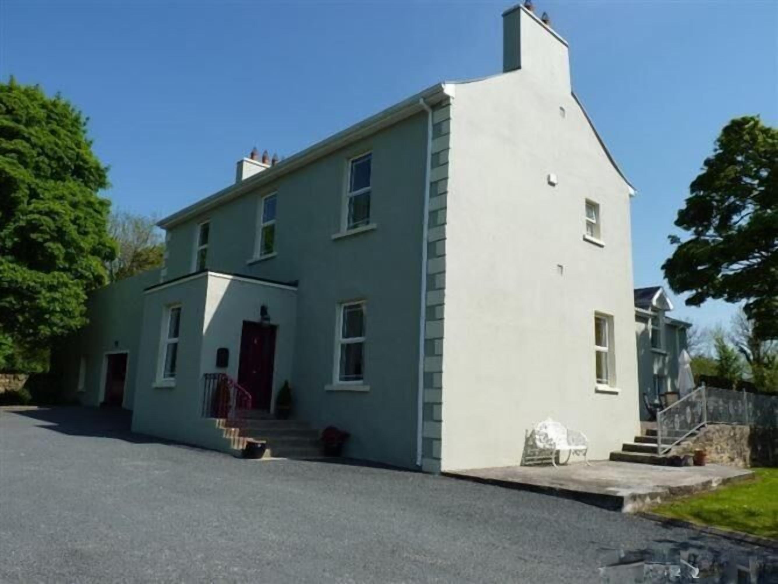 A two-story building with a red door and a chimney.