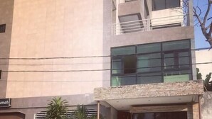 A modern building with a stone facade, a glass entrance, and a staircase leading to the entrance. - Residence djoumah (Abidjan)