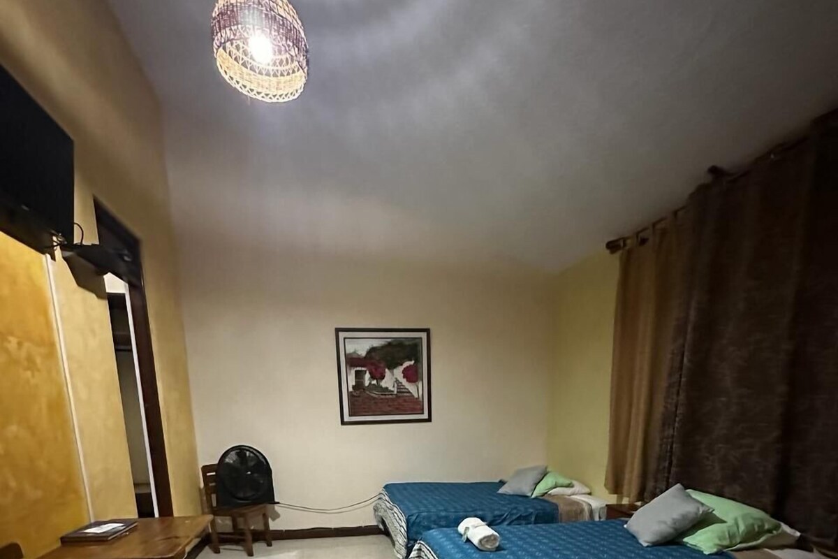 Ein Zimmer mit zwei Betten, einem Schreibtisch und einem Stuhl.