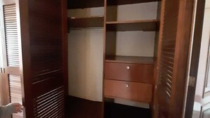 Een houten garderobe met verschillende vakken en een schuifdeur.