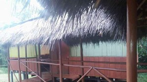 A wooden structure with a thatched roof, a wooden deck, and a simple railing. - Johmer Expedition Tours & Lodge (Iquitos)