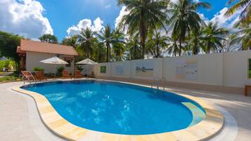 Alberca al aire libre y camastros