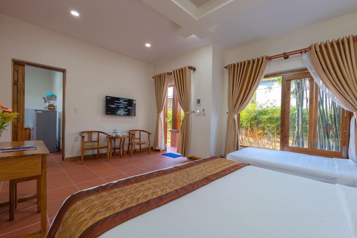 A hotel room with a bed, a desk, a chair, a television, and a window with curtains.
