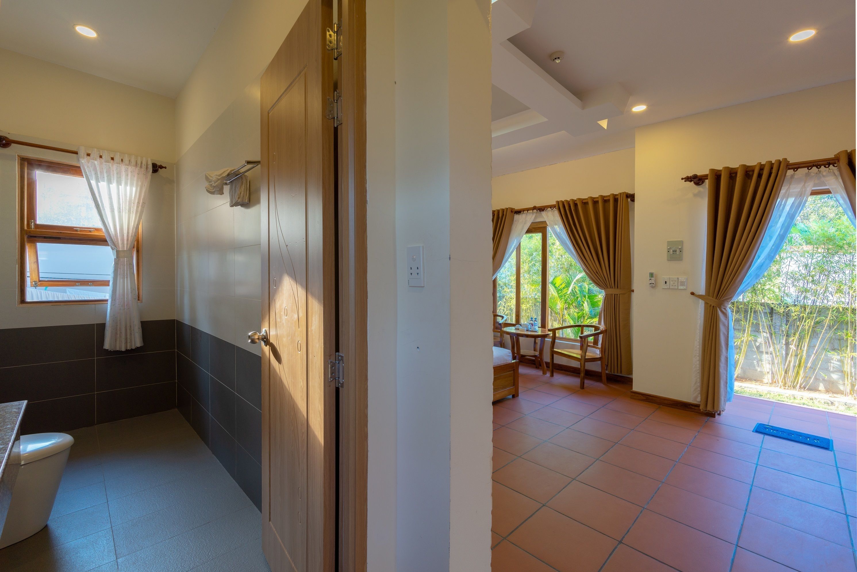 A bathroom with a toilet, a sink, and a shower area.