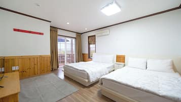 Una camera d'albergo con due letti, una scrivania, una finestra con tende e una lampada a soffitto.