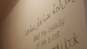 A staircase with a wall featuring Arabic text and English translation.