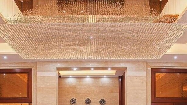 A hotel reception area with a check-in counter, two receptionists, and a clock on the wall. - Hangzhou Wangsu Hotel Letong (Hangzhou)