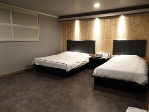 A bedroom with two beds, wooden panel walls, and a carpeted floor. - Kims Hotel Gumi (Gumi)