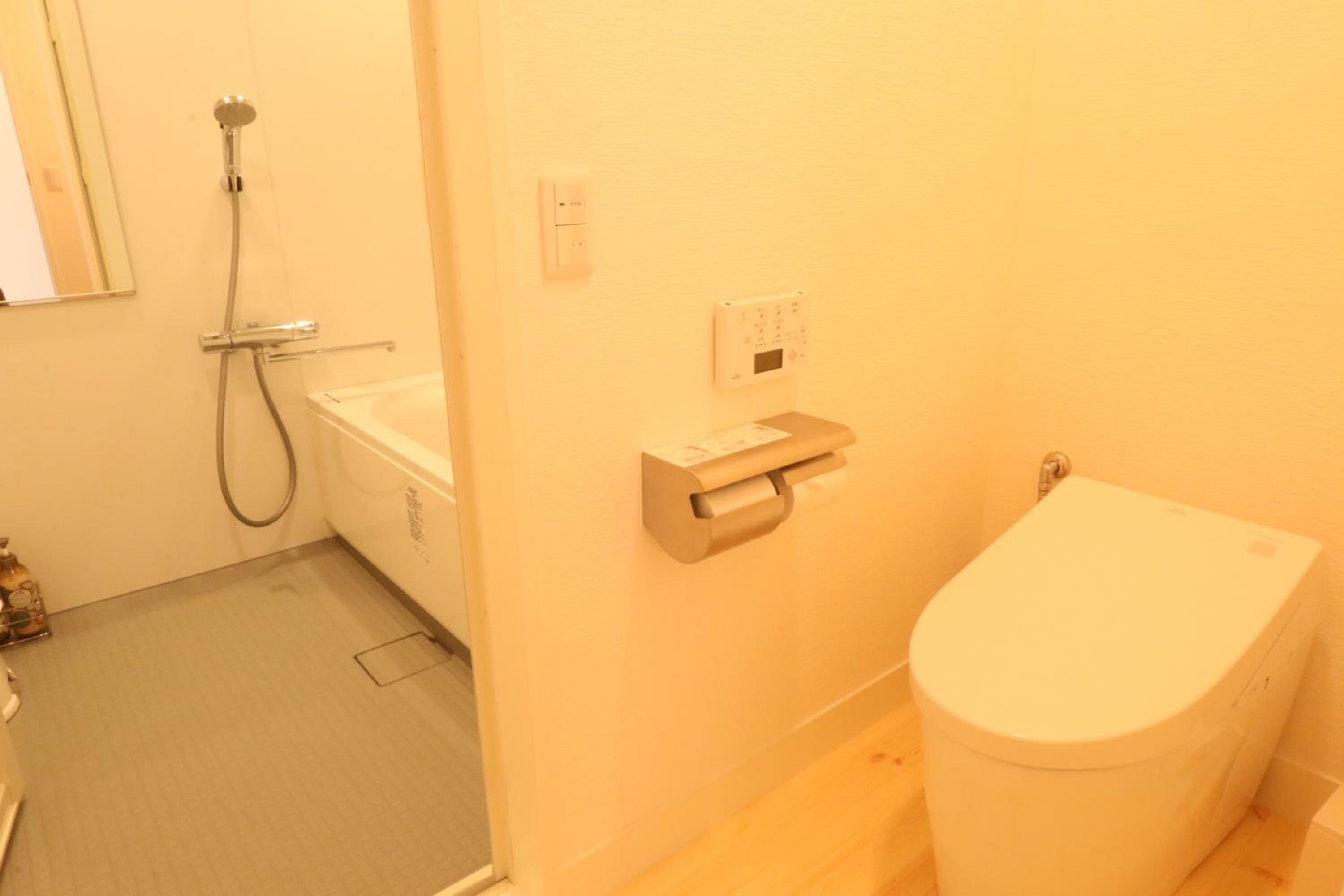A bathroom with a toilet, a bathtub, and a shower.