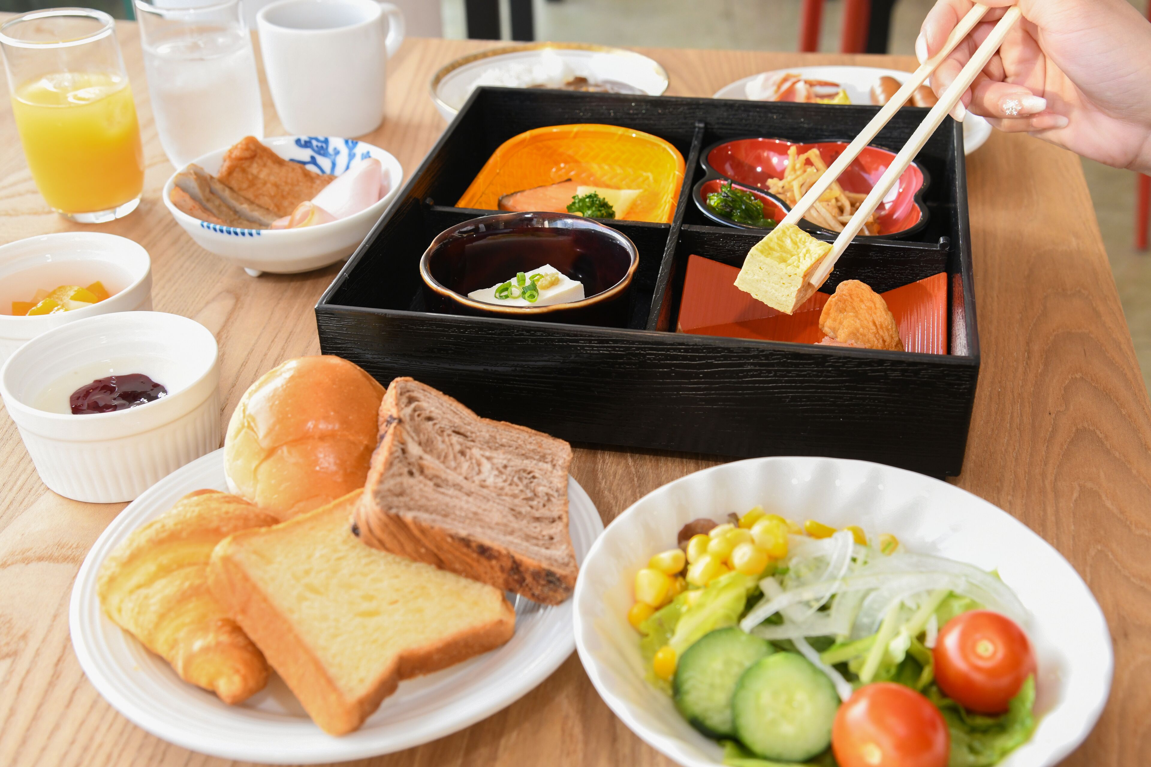 A meal tray with various dishes including bread, salad, and soup.