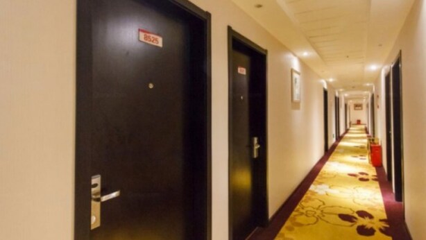 A hotel corridor with doors marked with room numbers, a carpeted floor, and a ceiling with recessed lighting. - 118 Inn Hangzhou Xiaoshan Nanxiu Road (Hangzhou)