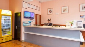 A reception desk with a computer monitor, framed certificates, and a vending machine. - 118 Inn Hangzhou Xiaoshan Nanxiu Road (Hangzhou)