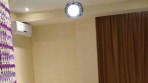 A hotel room with a bed, a ceiling light, a wall-mounted air conditioner, and a curtain. - 118 Inn Hangzhou Xiaoshan Nanxiu Road (Hangzhou)