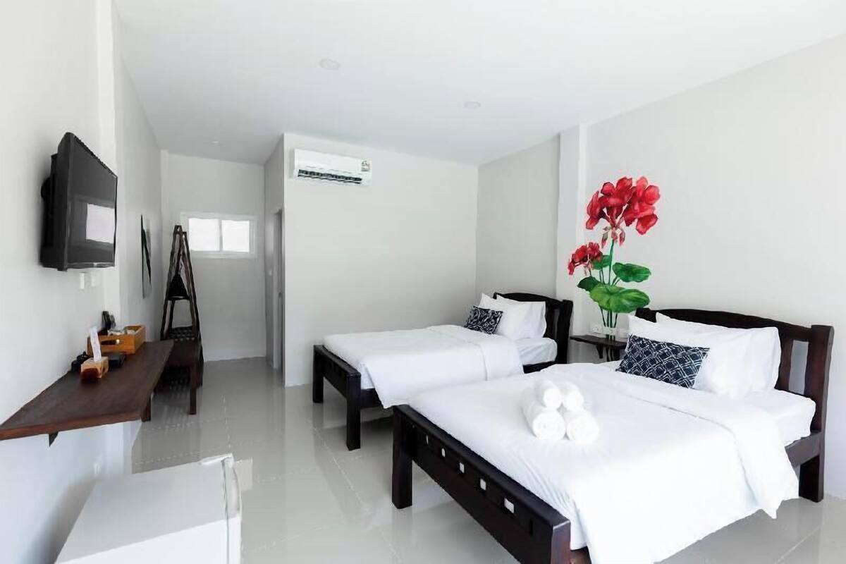 Habitación de hotel con dos camas, un televisor de pantalla plana, un escritorio y un ventanal grande.
