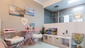 A modern bathroom with a glass shower enclosure, a white vanity, and a large mirror.