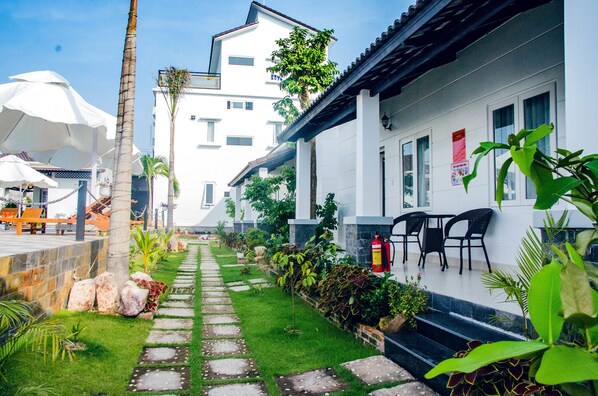 A pathway leading to a building with outdoor seating and a fire extinguisher.