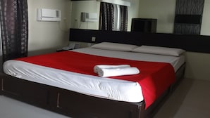 A hotel room with a large bed, a flat-screen TV, and a mirror above the bed. - Heilee's Guest House (General Santos)