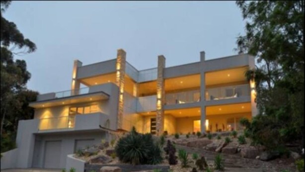 A modern multi-story house with a flat roof, large windows, and a well-lit entrance. - Hollywood Tree House (Burnside)