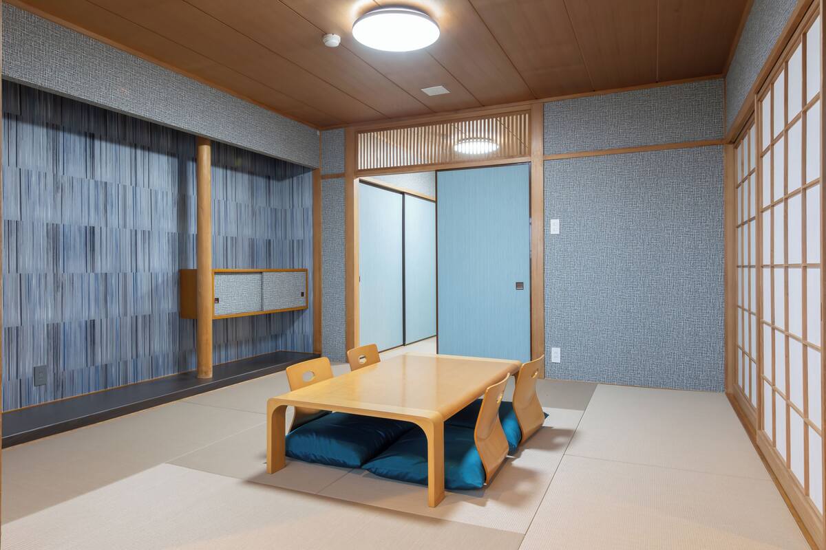 Une pièce de style japonais traditionnel, avec un sol recouvert de tatamis, une petite table en bois et des paravents en papier de riz (shoji).
