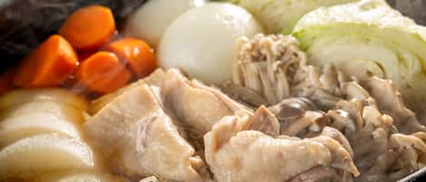 Una ciotola di zuppa con pollo, carote e cavolo.