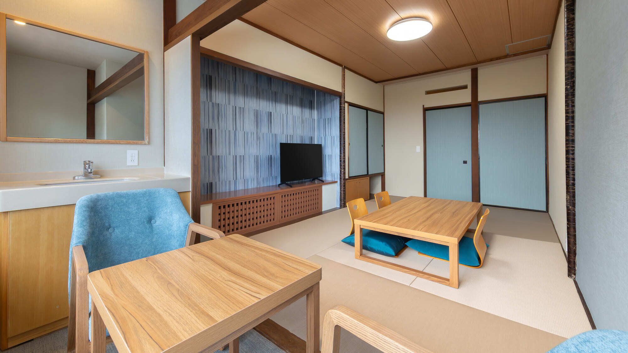Una habitación con una mesa de madera, sillas, un televisor y una puerta corredera.