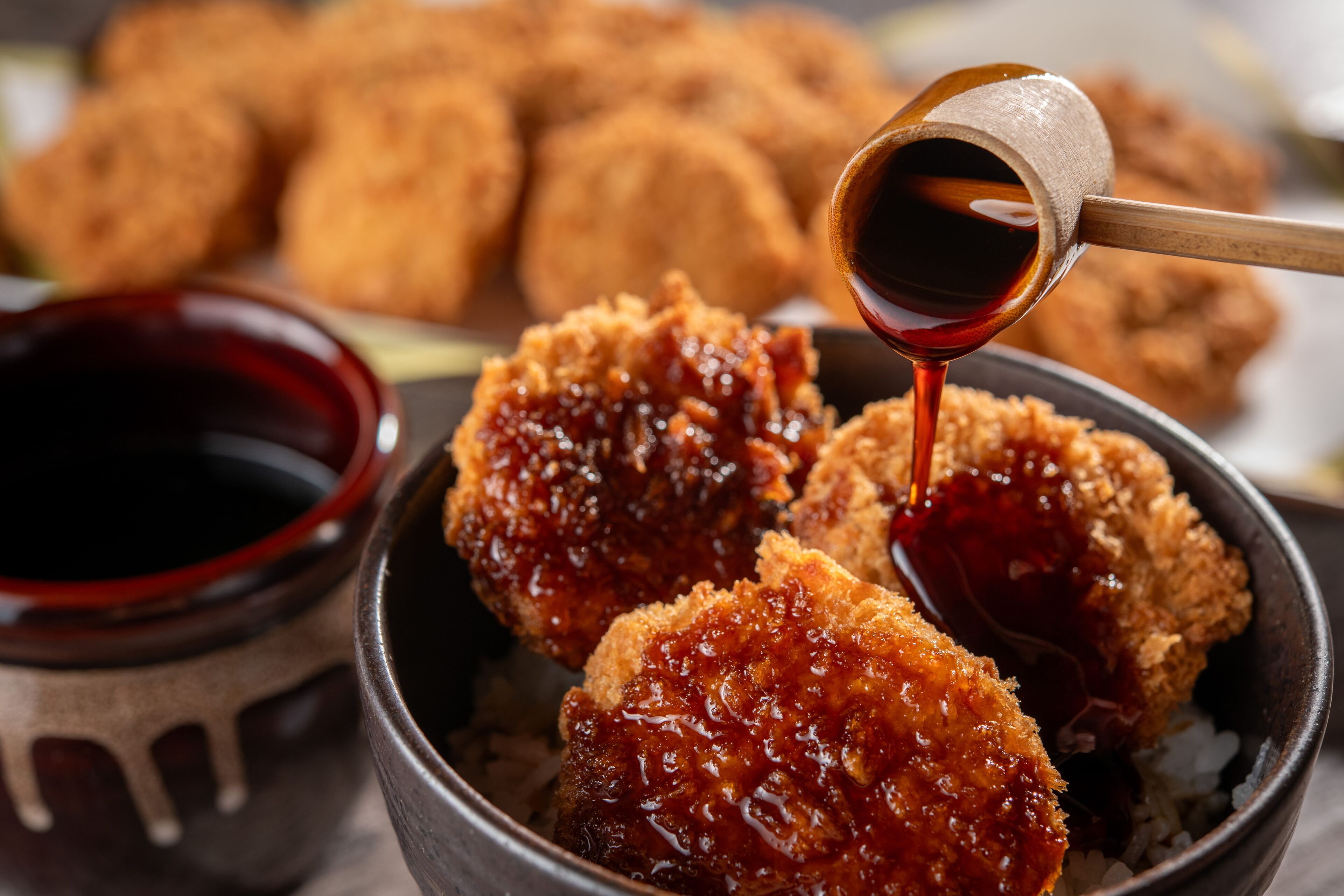 A bowl of fried food with a dipping sauce.