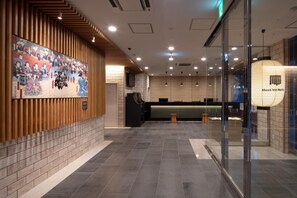 A hotel lobby with a traditional Japanese mural, a reception desk, and a modern interior design. - Meet Inn Narita (Narita)